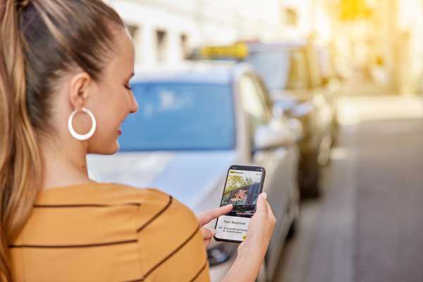 Fahrgästin bucht ein Taxi über die App auf ihrem Smartphone